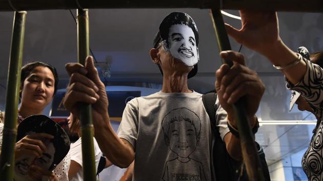 This file photo taken on June 22, 2017 shows activists standing behind makeshift bars wearing masks of Thai human rights activist Jatupat ‘Pai‘Boonpattararaksa, who was arrested in early December 2016 and charged with lese majeste for sharing a profile of King Maha Vajiralongkorn written by the BBC's Thai-language service in London on his Facebook page, during a demonstration in Bangkok. (AFP File Photo) This file photo taken on June 22, 2017 shows activists standing behind makeshift bars wearing masks of Thai human rights activist Jatupat ‘Pai‘Boonpattararaksa, who was arrested in early December 2016 and charged with lese majeste for sharing a profile of King Maha Vajiralongkorn written by the BBC's Thai-language service in London on his Facebook page, during a demonstration in Bangkok. (AFP File Photo)