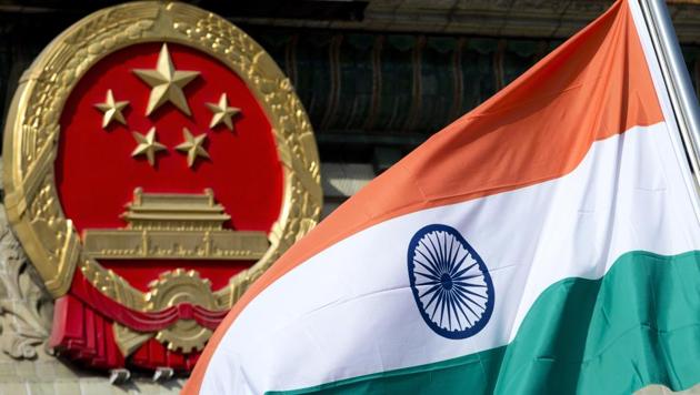 In this file photo, an Indian national flag is seen next to the Chinese national emblem during a welcome ceremony for visiting Indian officials outside the Great Hall of the People in Beijing. Tensions are running high between the two countries after China called for the immediate withdrawal of Indian troops from Doklam.(AP)