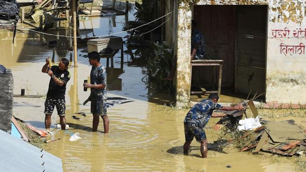 Nepalese police officers clean their office at Tilathi village in Saptari district, 450 km southeast of Kathmandu, on August 15, 2017. At least 221 people have died and more than 1.5 million have been displaced by monsoon flooding across India, Nepal and Bangladesh, officials said.(AFP)