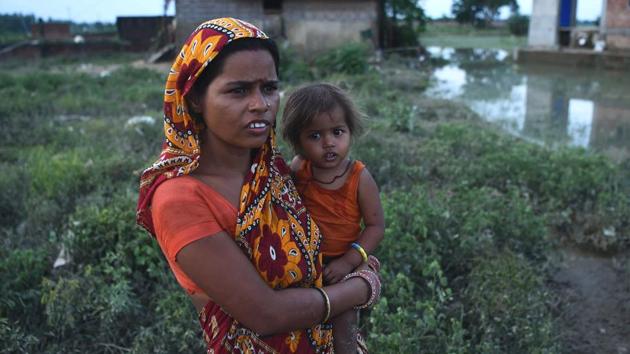 A Nepalese woman poses with her child amid floodwaters in Janakpur, Kathmandu. More than 50,000 houses were inundated across the plains and over 22,000 people displaced so far. (Prakash Mathema / AFP)