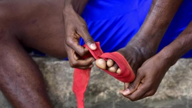 Usman from West Africa prepares for a match against a local team during Independence Day Cup at Bengaluru east Stadium. With only socks and anklet braces on their feet, the players throng to the field often risking their health.  (Arijit Sen/HT Photo) 
