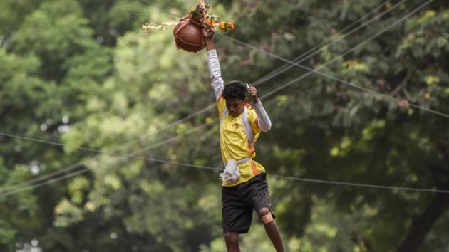 A youth hangs holding a dahi handi in Dadar on Tuesday.(Kunal Patil/HT)