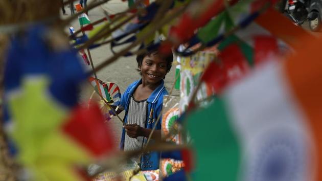 A boy sells national flags at Satara road, in Pune, on Monday, August 14, 2017.  (Rahul Raut/HT PHOTO) 