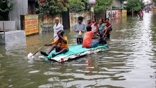 People wade through a flooded road due to the overflowing of Atreyee river in South Dinajpur district of West Bengal on August 16, 2017.(PTI Photo)