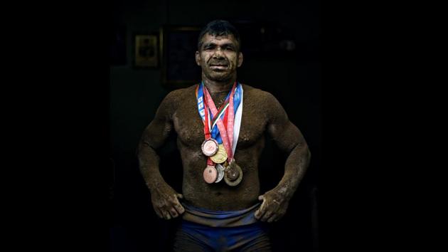 Deaf Olympic Gold medalist wrestler Virender Singh poses for a portrait with his medals at his akhara near Sadar Bazar in New Delhi.(Ravi Choudhary/HT PHOTO)