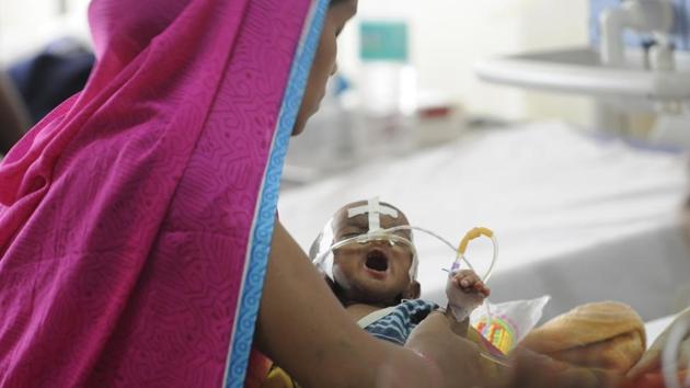 A mother cradles her child inside the encephalitis ward at the Baba Raghav Das Medical College in Gorakhpur, on August 15, 2017. (Deepak Gupta/HT Photo) A mother cradles her child inside the encephalitis ward at the Baba Raghav Das Medical College in Gorakhpur, on August 15, 2017. (Deepak Gupta/HT Photo)