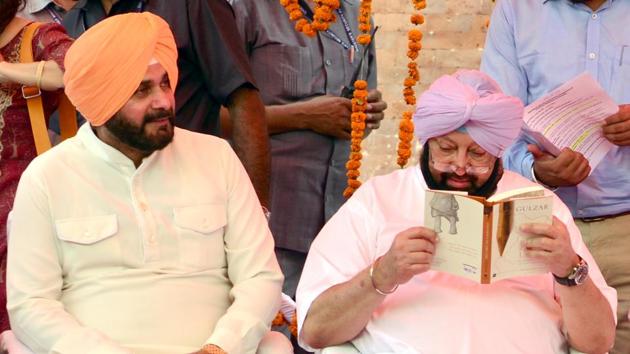 Captain Amarinder Singh reading Gulzar’s book ‘Footprints on Zero Line: Writings on the Partition’ with Navjot Sidhu on his left. (Sameer Sehgal/HT)