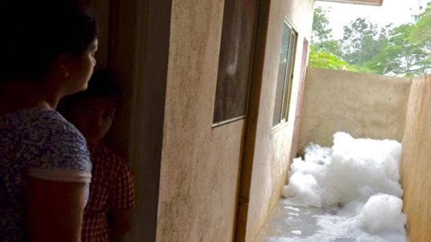 A woman watches as froth from the polluted Bellandur lake in Bengaluru is blown into her housing complex. (Arijit Sen/ HT Photo) A woman watches as froth from the polluted Bellandur lake in Bengaluru is blown into her housing complex. (Arijit Sen/ HT Photo)