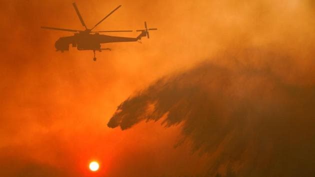 Five firefighting planes and six water-throwing helicopters operated through Wednesday amid thick, billlowig smoke, assisting 210 firefighters and about 100 military personnel battling the blaze on the ground near the town of Kapandriti. Rugged terrain dotted with small communities and winds rekindling the blaze made fire-fighting difficult. (Giorgos Moutafis / REUTERS)