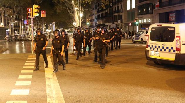 Armed Catalonian Mosses de Escuadra officers leave the area where a van crashed into pedestrians at Las Ramblas in Barcelona. (REUTERS) Armed Catalonian Mosses de Escuadra officers leave the area where a van crashed into pedestrians at Las Ramblas in Barcelona. (REUTERS)