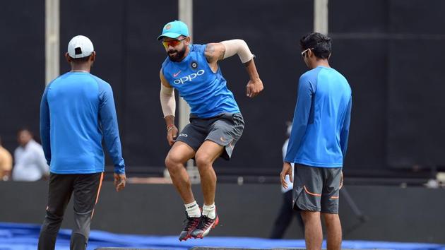 Virat Kohli (C) warms up as teammates look on during a practice session. (AFP) Virat Kohli (C) warms up as teammates look on during a practice session. (AFP)