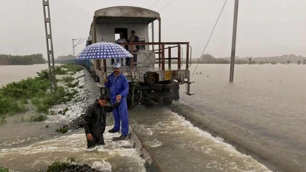 A goods train halts on the flooded tracks as railway empolyees inspect the damaged embankment along the Katihar-Guwahati line, in Katihar district of Bihar on Monday. (PTI Photo) A goods train halts on the flooded tracks as railway empolyees inspect the damaged embankment along the Katihar-Guwahati line, in Katihar district of Bihar on Monday. (PTI Photo)