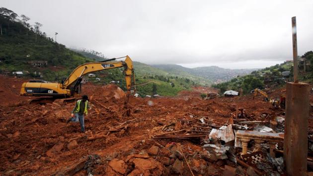 Heavy machines are seen during rescue work at the place of the mudslide in the mountain town of Regent, Sierra Leone. With large portions buried under the deluge of water bringing down tonnes of debris, the outcome of rescue work remains grim. (Afolabi Sotunde / REUTERS)