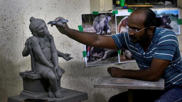 Artist Vishal Shinde works on a clay idol. (Anshuman Poyrekar/HT Photo) 