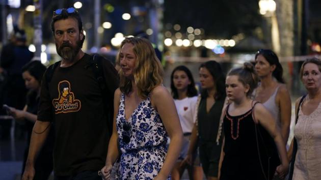 A woman cries as she and others are escorted by Spanish policemen outside a cordoned off area after a van ploughed into the crowd, killing 13 persons and injuring over 100 on the Rambla in Barcelona on August 17, 2017.(AFP Photo) A woman cries as she and others are escorted by Spanish policemen outside a cordoned off area after a van ploughed into the crowd, killing 13 persons and injuring over 100 on the Rambla in Barcelona on August 17, 2017.(AFP Photo)