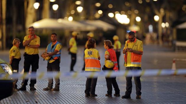 Emergency workers stand on a blocked street in Barcelona, Spain. Spanish Prime Minister Mariano Rajoy said on Twitter he was en route to Barcelona. ‘Maximum coordination to arrest the attackers, reinforce security and attend to all those affected,’ he said. (AP)