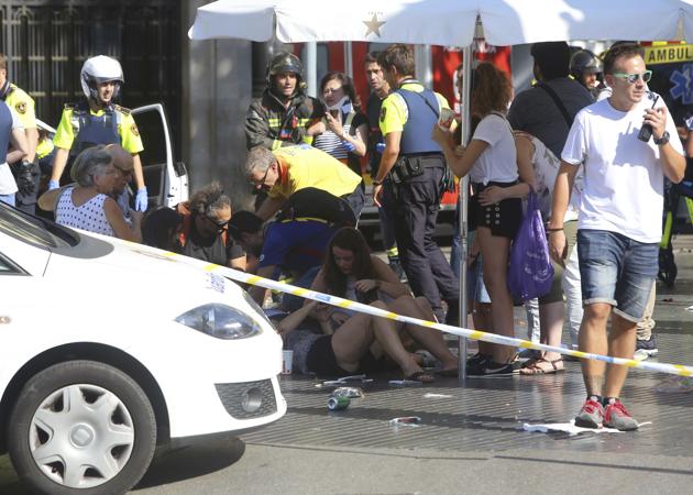 Injured people are treated after a white van ploughed through a crowd in Barcelona on August 17, 2017.