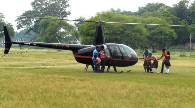 Kids climbing on board the helicopter before their ride in Kaushambi. (Ht Photo) Kids climbing on board the helicopter before their ride in Kaushambi. (Ht Photo)