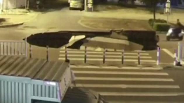 In the video, the man is shown approaching a sinkhole looking at his mobile phone. (YouTube screengrab) In the video, the man is shown approaching a sinkhole looking at his mobile phone. (YouTube screengrab)