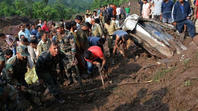 Indian army personnel and rescue workers search for survivors amid the rubble after a landslide caused by a cloudburst swept two buses off the road into a gorge, in Mandi district, in the northern state of Himachal Pradesh. (REUTERS)