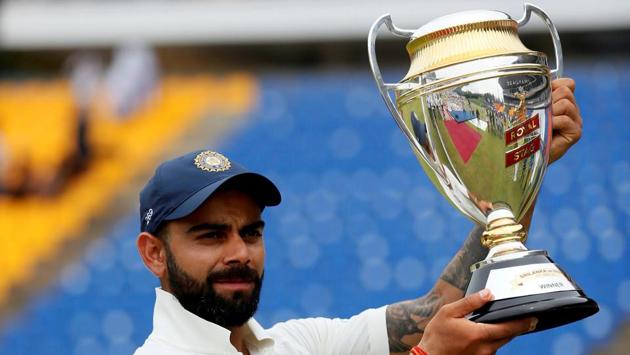 Virat Kohli holds the trophy for photographs after they won the match and test cricket series against Sri Lanka. (Dinuka Liyanawatte/REUTERS)