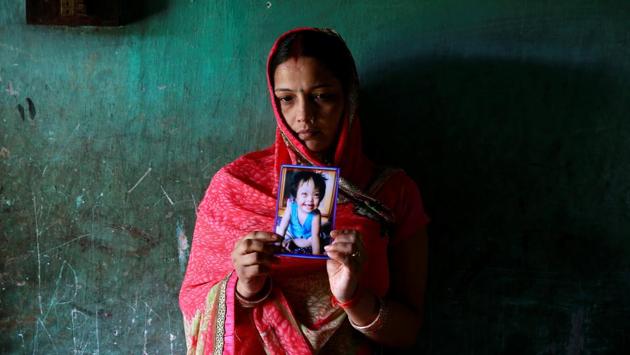 Rinki Singh, 31, holds a photo of her daughter Aarushi, 6, who died in the intensive care unit (ICU) of the Baba Raghav Das hospital in the Gorakhpur district on August 14. (Cathal McNaughton/REUTERS)