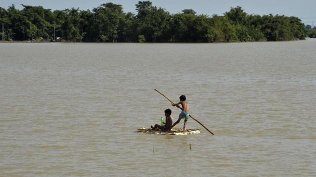 This file photo taken on August 19, 2017 shows children using a raft to travel over flood waters in Araria in Bihar.(AFP)