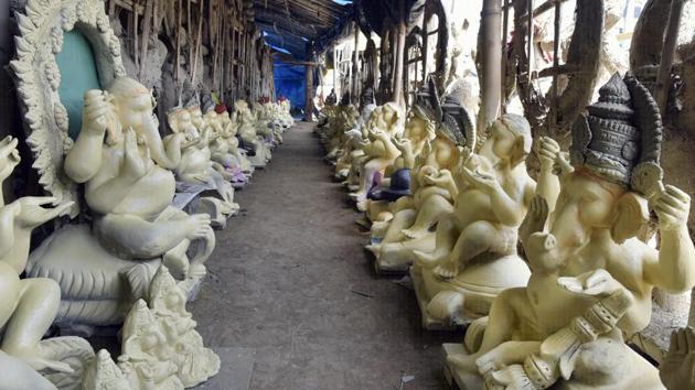 The idols, in various stages of completion await prospective buyers wishing to take them home. Mostly seen sitting, these idols are viewed as guests to the household while the festive rituals and immersions are performed and as a gesture of hospitality are offered seats from the get go. The prevalence of the seated posture also allows the idol makers to offset the weight of the idol --a more comfortable position for both creator and creation. (Mohd Zakir / HT Photo)