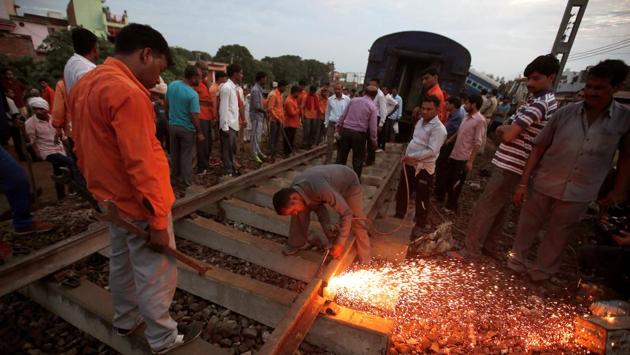 A railway worker repairs the tracks next to derailed coaches of a passenger train, at the site of an accident in Khatauli in the northern state of Uttar Pradesh. (Adnan Abidi/REUTERS)