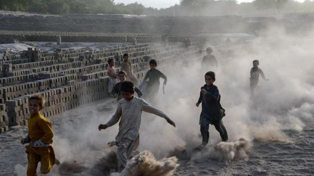 Afghan children run as they play along a dusty road on the outskirts of Jalalabad. (Noorullah Shirzada/AFP)