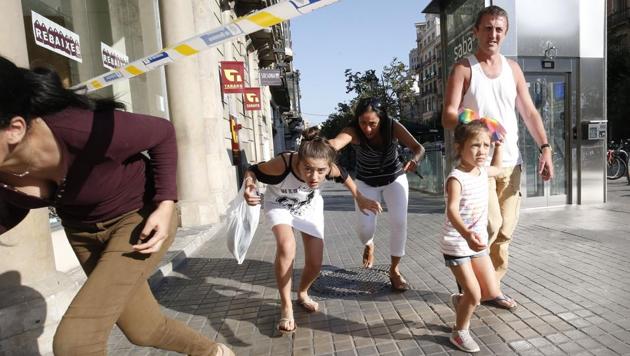 People leave a cordoned off area after a van ploughed into the crowd, killing one person and injuring several others on the Rambla in Barcelona on August 17, 2017. (Pau Barrena/AFP)