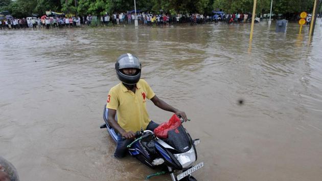 Two-wheelers could be seen wading through knee-deep water that had accumulated on roads from clogged drainage systems, exposing claims of civic authorities on preparations to deal with logging problems. (KEshav Singh/HT) Two-wheelers could be seen wading through knee-deep water that had accumulated on roads from clogged drainage systems, exposing claims of civic authorities on preparations to deal with logging problems. (KEshav Singh/HT)