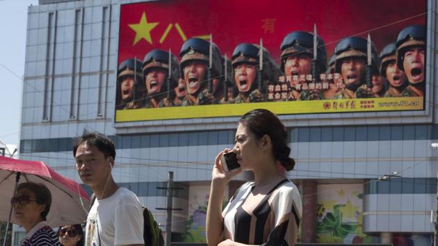 People wait at a traffic junction near a billboard advertising the Chinese military in Beijing, China, Friday, Aug. 4, 2017. Beijing is intensifying its warnings to Indian troops to get out of Doklam. (AP) People wait at a traffic junction near a billboard advertising the Chinese military in Beijing, China, Friday, Aug. 4, 2017. Beijing is intensifying its warnings to Indian troops to get out of Doklam. (AP)