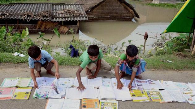 School students laid their books on the road for drying in a flood-affected village in Morigaon district of Assam.(PTI File Picture)