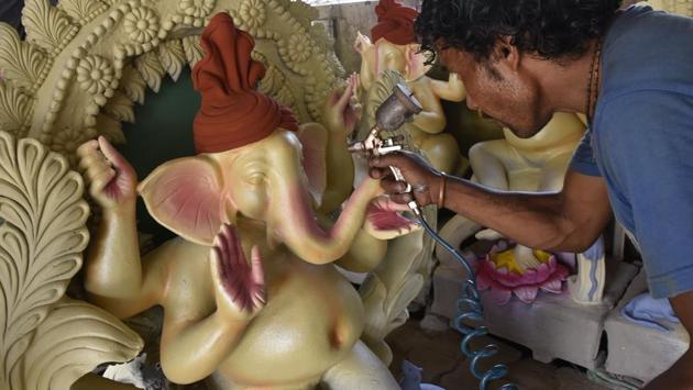 In the final step, the idols are airbrushed in bright hues and their highlights and motifs painted by hand. They are also draped, decorated with painted or actual jewellery and given their associated accessories. (Mohd Zakir / HT Photo)