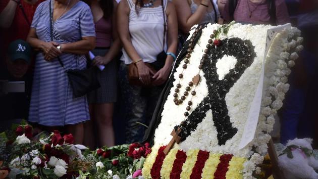 People stand next to flowers, candles and other items set up on the Las Ramblas boulevard in Barcelona as they pay tribute to the victims of the Barcelona attack, three days after a van ploughed into the crowd, killing 13 persons and injuring over 100 on August 20, 2017. (AFP) People stand next to flowers, candles and other items set up on the Las Ramblas boulevard in Barcelona as they pay tribute to the victims of the Barcelona attack, three days after a van ploughed into the crowd, killing 13 persons and injuring over 100 on August 20, 2017. (AFP)