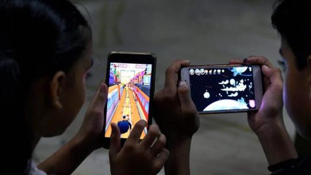 Children play games on mobile phones in New Delhi. (PTI) Children play games on mobile phones in New Delhi. (PTI)