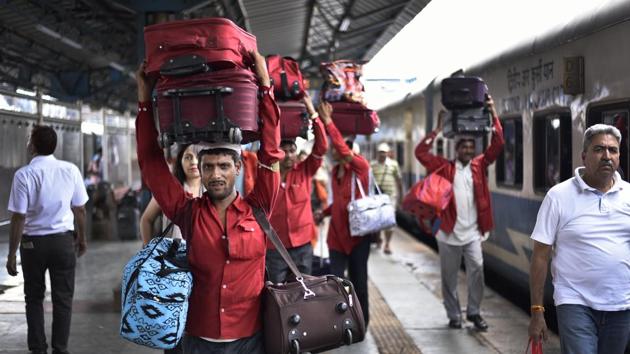 The nearly 20,000 coolies present across India by definition are not employees of the Indian Railways. Their employment depends on the payment of an annual license fee and they draw no salary from the government. The Railways reviews their rate cards and has pegged prices at ₹60 for 40kg, but these do not accurately reflect on-ground prices which are dictated by demand and supply for their services across railway stations. (Burhaan Kinu / HT Photo)