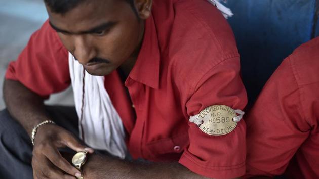 The coolie or train porter in his bright red shirt and copper armband has been ubiquitous at Indian railway stations ferrying luggage to and from trains – even glamorised in cinema courtesy Amitabh Bachchan. Once the go-to option for passengers looking for quick passage through platforms, newer infrastructure facilities for the aid of commuters have greatly reduced dependence on these porters. Their concerns are compounded by demands for better working conditions and occupational perks. (Burhaan Kinu / HT Photo)