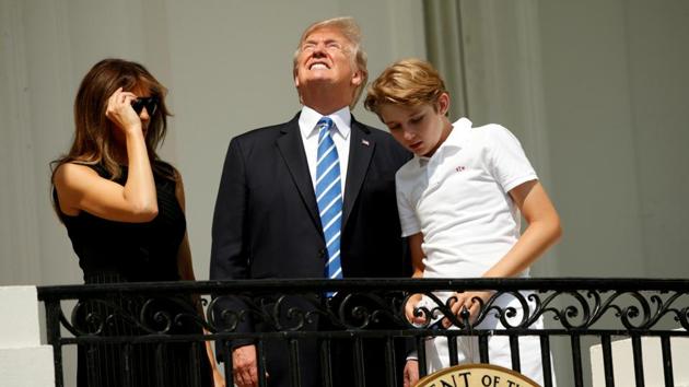 U.S. President Donald Trump looks up towards the solar eclipse without his protective glasses along with his wife Melania and son Barron at the White House in Washington U.S.The rare cosmic event was expected to draw one of the largest audiences in human history. (REUTERS)