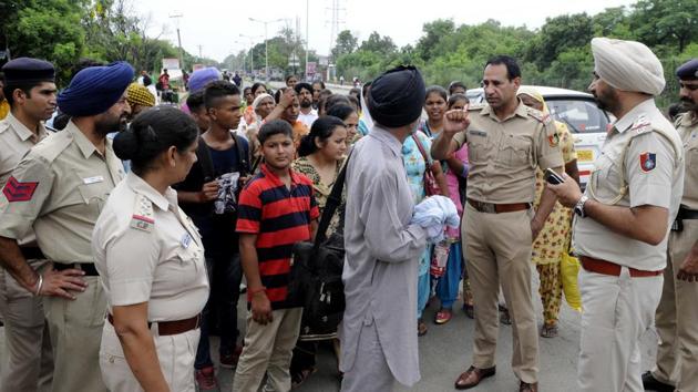 Police interacting with the followers of Dera Sacha Sauda near Chandigarh railway station on Wednesday. (Keshav Singh/HT) Police interacting with the followers of Dera Sacha Sauda near Chandigarh railway station on Wednesday. (Keshav Singh/HT)