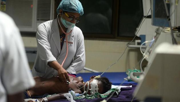 Medical staff attend to a child admitted in the encephalitis ward at the BRD Medical College in Gorakhpur. (AFP Photo) Medical staff attend to a child admitted in the encephalitis ward at the BRD Medical College in Gorakhpur. (AFP Photo)