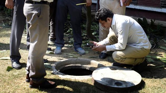 Delhi Police officers investigate the sewer where Rishi Pal died at Lok Nayak Hospital on Sunday. (Sonu Mehta/HT Photo) Delhi Police officers investigate the sewer where Rishi Pal died at Lok Nayak Hospital on Sunday. (Sonu Mehta/HT Photo)
