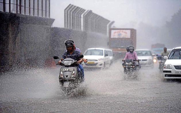 People caught in the Monsoon rain near Moti Bagh in New Delhi, India, on Wednesday.(Arun Sharma/HT PHOTO)