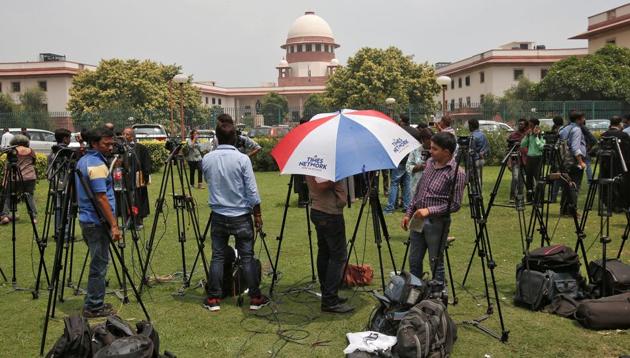 Television journalists are seen outside the premises of the Supreme Court in New Delhi.(REUTERS)