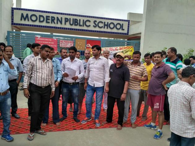 Agitated parents staged a sit in outside modern public school in Shahberi GB Nagar. (HT Photo) Agitated parents staged a sit in outside modern public school in Shahberi GB Nagar. (HT Photo)