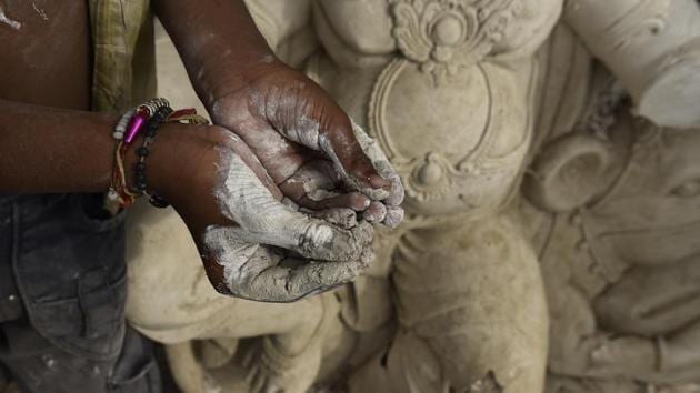 An artists shows his hands caked in clay used to make idols of the elephant-headed Hindu God Ganesha ahead of Ganesh Chaturthi a workshop, in New Delhi. Ganesha, who is also known as Ganpati and Vinayak is widely worshiped as the god of wisdom, prosperity and good fortune. (Burhaan Kinu / HT Photo)