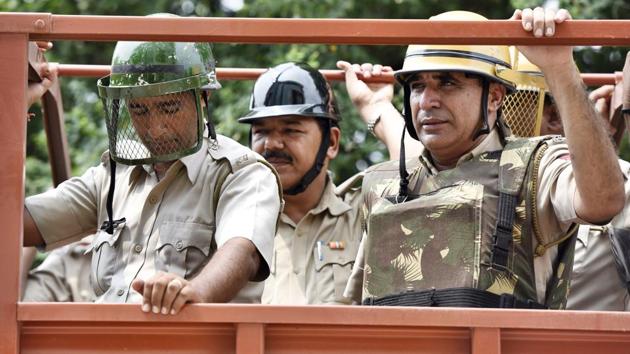 Gurugram police holds flag march on high alert following Baba Gurmeet Ram Rahim’s rape trial verdict which pronounced him guilty. The Dera Sacha Sauda Chief will be taken to Rohtak by chopper. Meanwhile violence has been reported in Panchkula with police resorting to tear gas shells to handle growing mobs. (Sanjeev Verma / HT PHOTO)