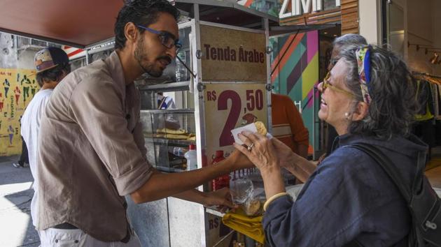 Egyptian immigrant Mohamed Ali Abdelmoatty Kenawy, who was attacked three weeks ago by four men screaming "Go back to your country!", attends to a customer at his food stand in the Copacabana neighborhood in Rio de Janeiro on August 24, 2017. (AFP Photo) Egyptian immigrant Mohamed Ali Abdelmoatty Kenawy, who was attacked three weeks ago by four men screaming "Go back to your country!", attends to a customer at his food stand in the Copacabana neighborhood in Rio de Janeiro on August 24, 2017. (AFP Photo)