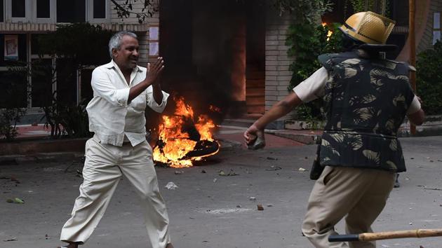 A follower of dera chief Gurmeet Ram Rahim Singh pleads for his safety after being hit with a stick during clashes between the controversial guru's followers and security forces in Panchkula. (AFP)